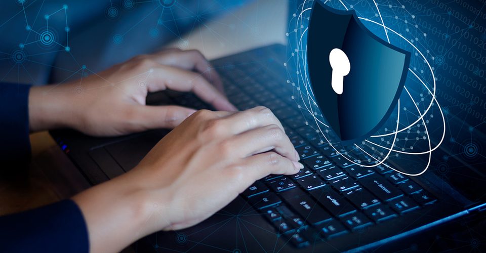 A person typing on a laptop with a security symbol on the screen | Cyber Essentials in Falkirk | Data Recovery in Falkirk, Cybersecurity in Falkirk, IT Services in Falkirk